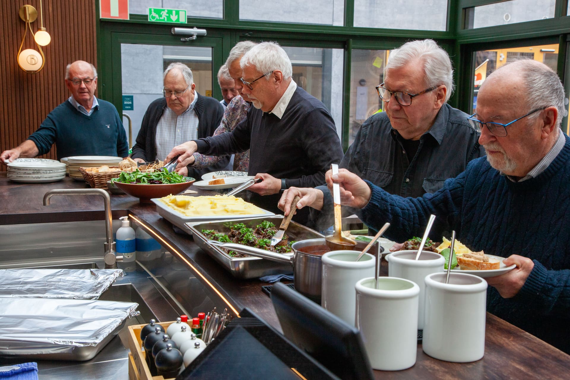 Medlemmar samlade till borgarlunch på restaurang.